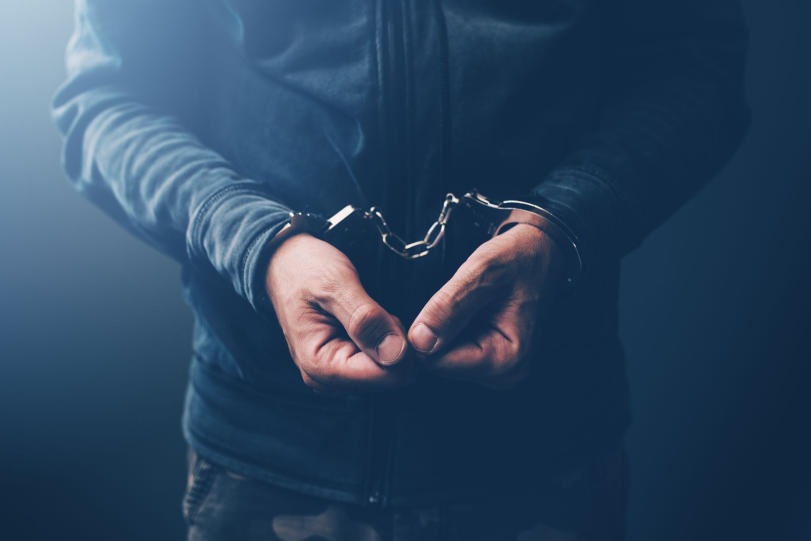Arrested computer hacker and cyber criminal with handcuffs close up of hands Chalking up a win for the good guys
